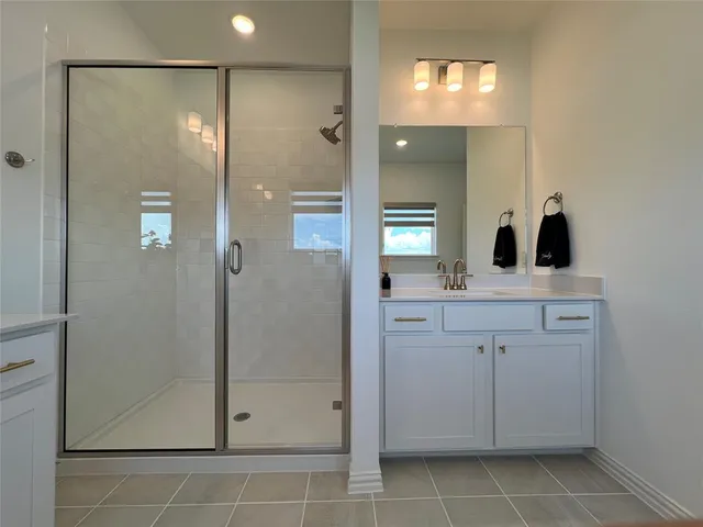 a bathroom with a shower sink and mirror