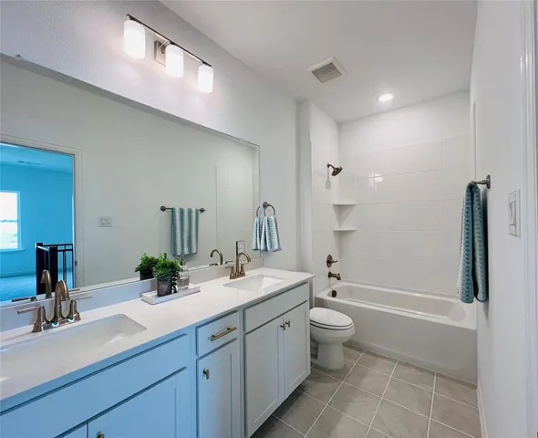 a spacious bathroom with a double vanity sink toilet and shower