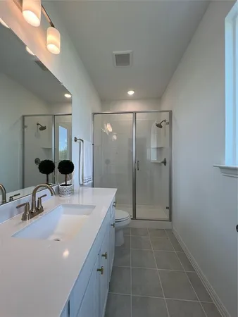 a bathroom with a double vanity sink mirror double shower and a mirror