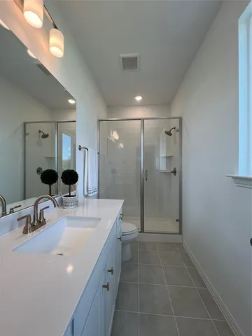 a bathroom with a double vanity sink mirror double shower and a mirror