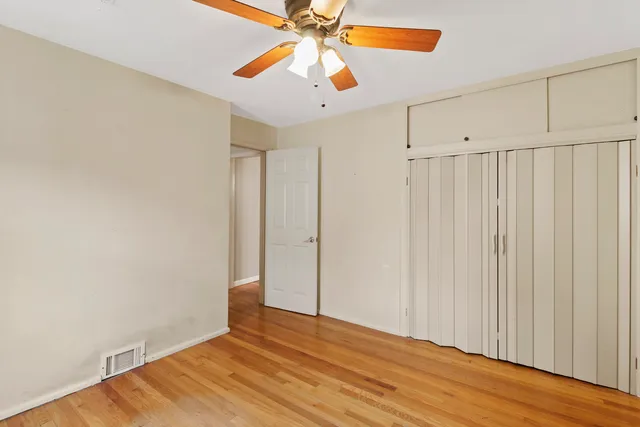 a view of a livingroom with wooden floor and a ceiling fan
