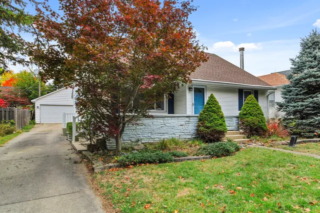 a front view of a house with a yard and trees