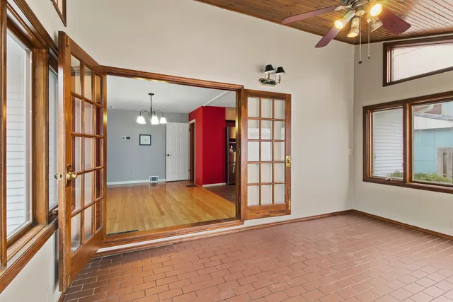 a view of an empty room with window and chandelier