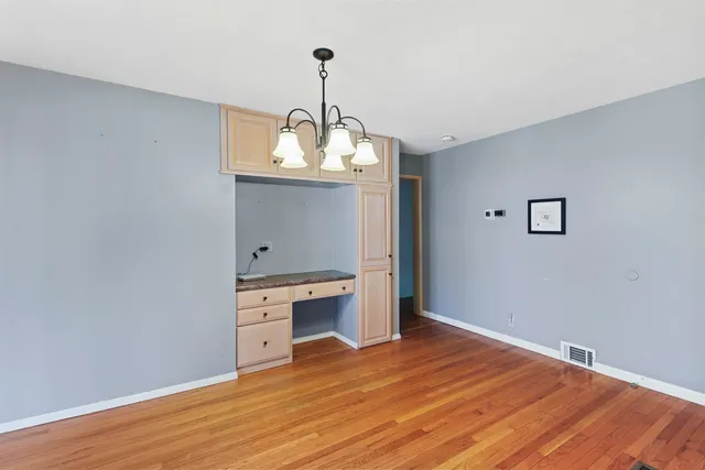 a view of a kitchen with a sink wooden floor and a chandelier