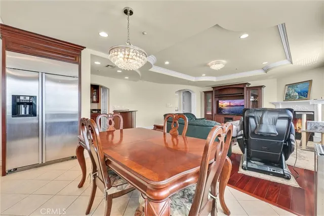 a dining room with stainless steel appliances kitchen island granite countertop a table chairs and a refrigerator
