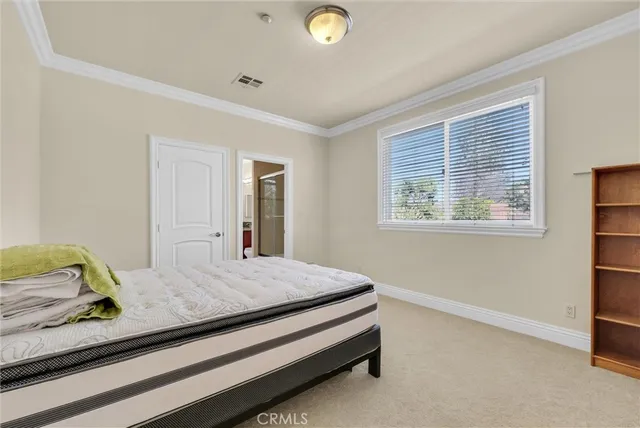 a white house with a yard and table and chairs under an umbrella
