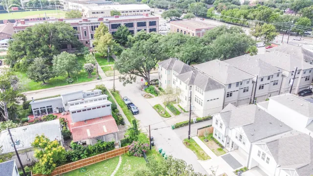 an aerial view of residential houses with outdoor space and parking