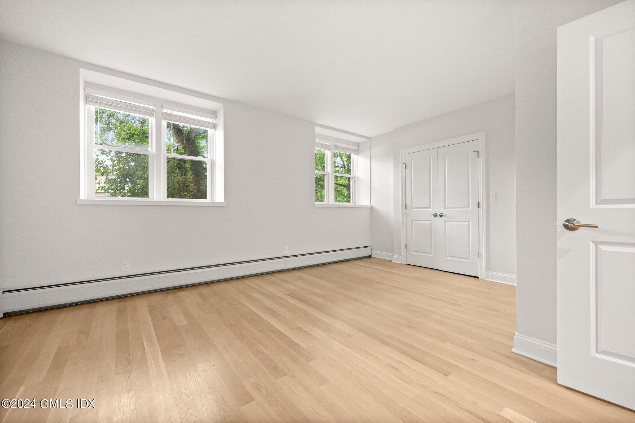 36 Arch Street, Unit 1A Greenwich, CT 06830 - Photo 12 of 19 a view of an empty room with wooden floor and a window