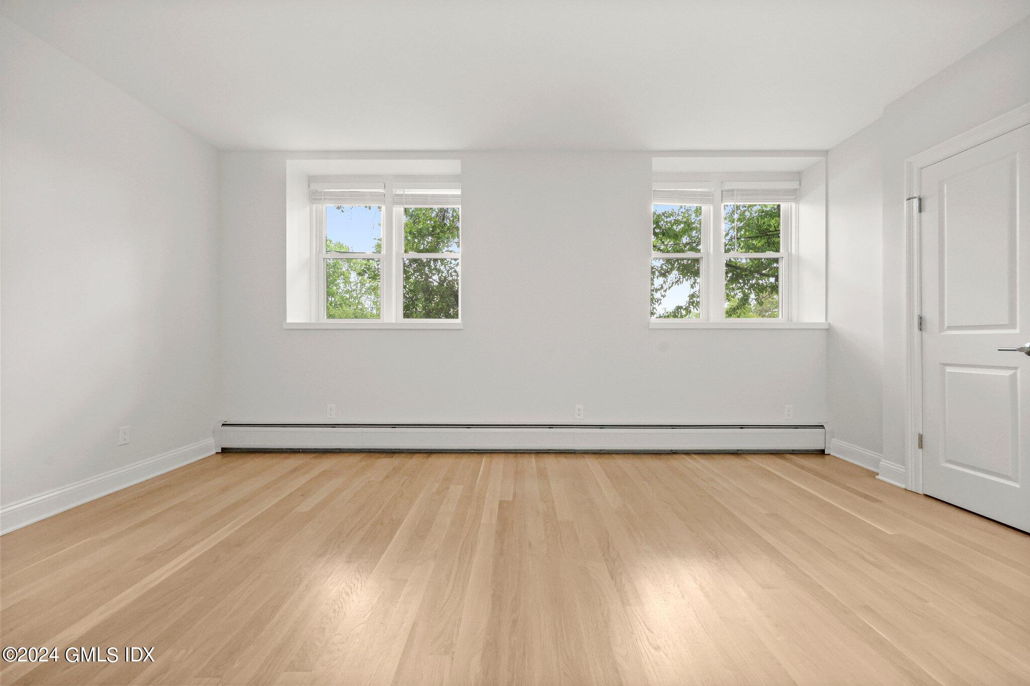 36 Arch Street, Unit 1A Greenwich, CT 06830 - Photo 14 of 19 an empty room with wooden floor and windows