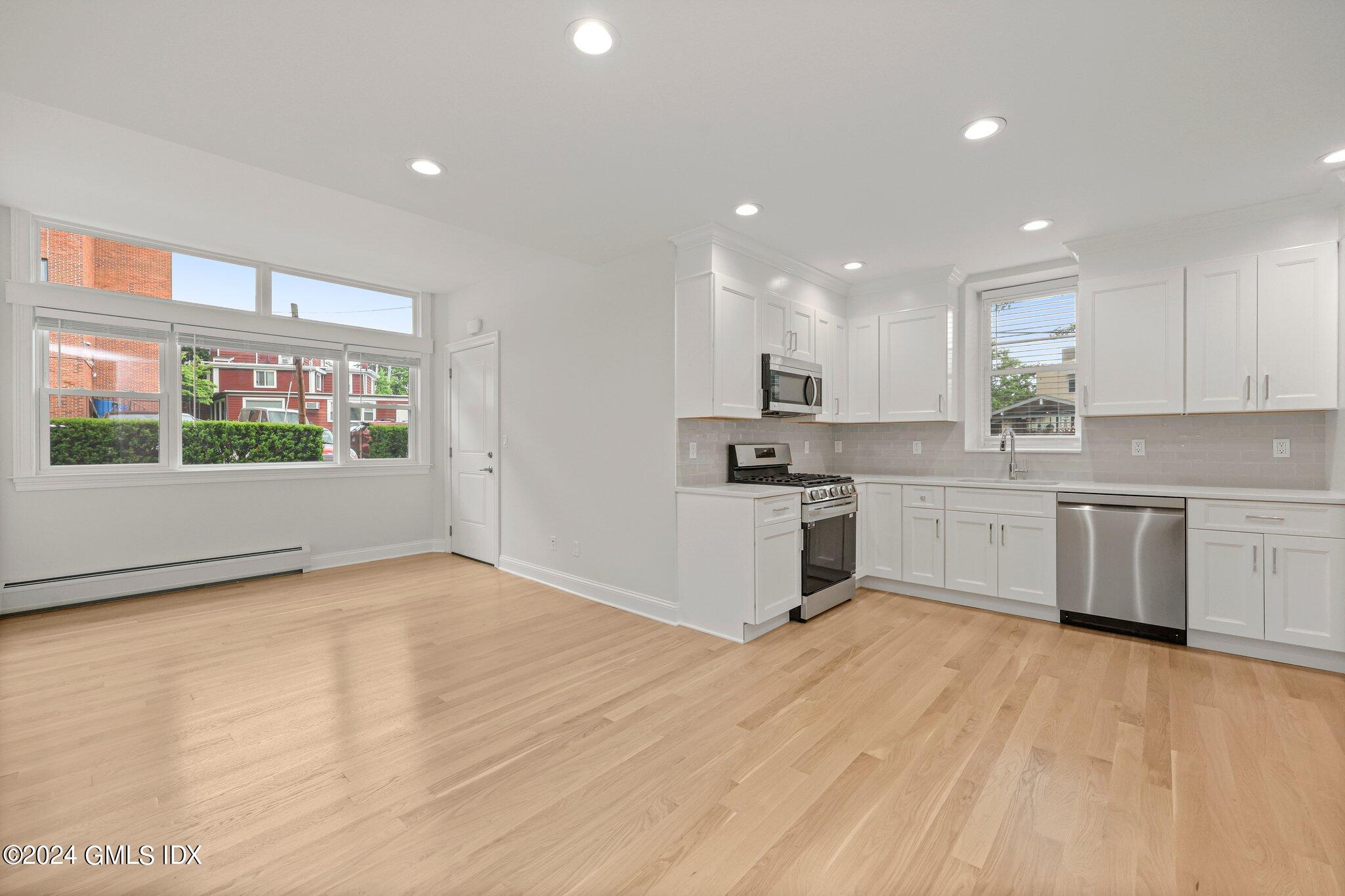 36 Arch Street, Unit 1A Greenwich, CT 06830 - Photo 10 of 19 a kitchen with stainless steel appliances a white stove top oven sink and window