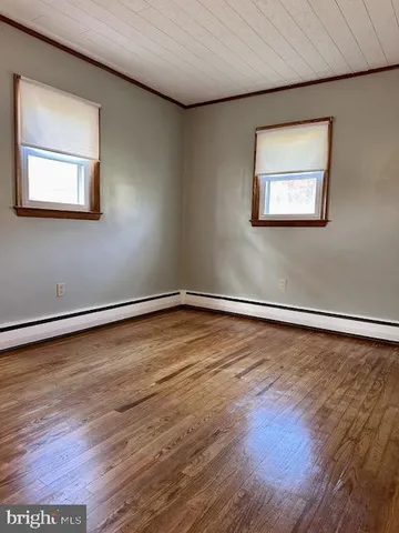 a view of a room with wooden floor and white walls