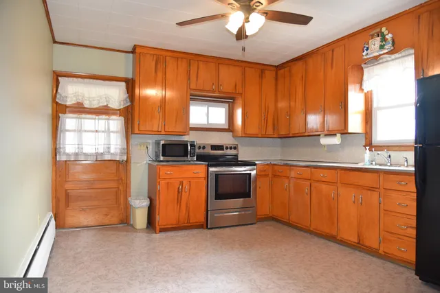 a kitchen with stainless steel appliances granite countertop a stove a sink and a refrigerator