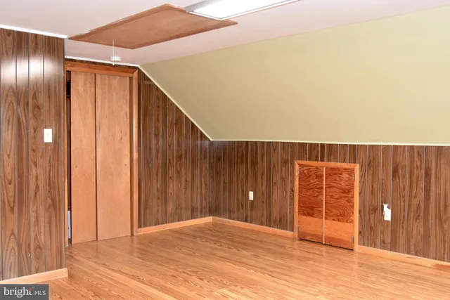 a view of an empty room with wooden floor and entryway
