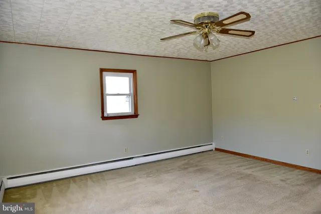 an empty room with a window and a fan