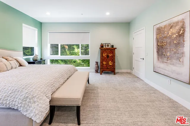 a living room with furniture a large window and gym equipment