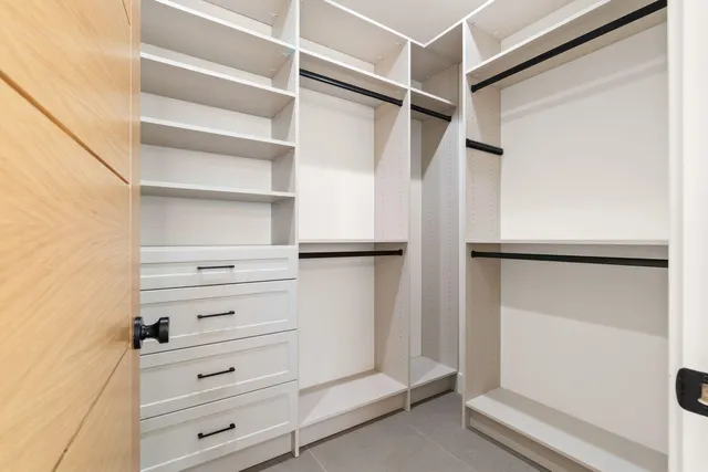 a view of walk in closet with empty racks
