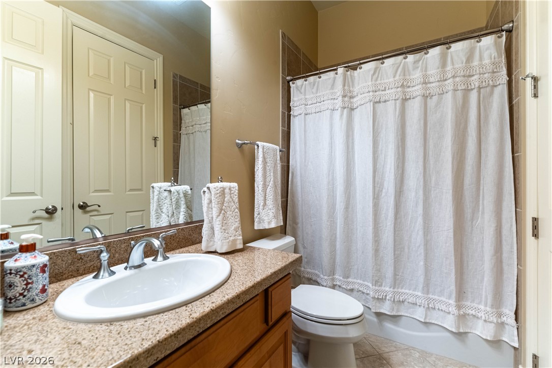 3661 Riley Ann Avenue Las Vegas, NV 89139 - Photo 28 of 42 A well-appointed bathroom features a single vanity with granite counters and a clean, functional shower-tub combination.