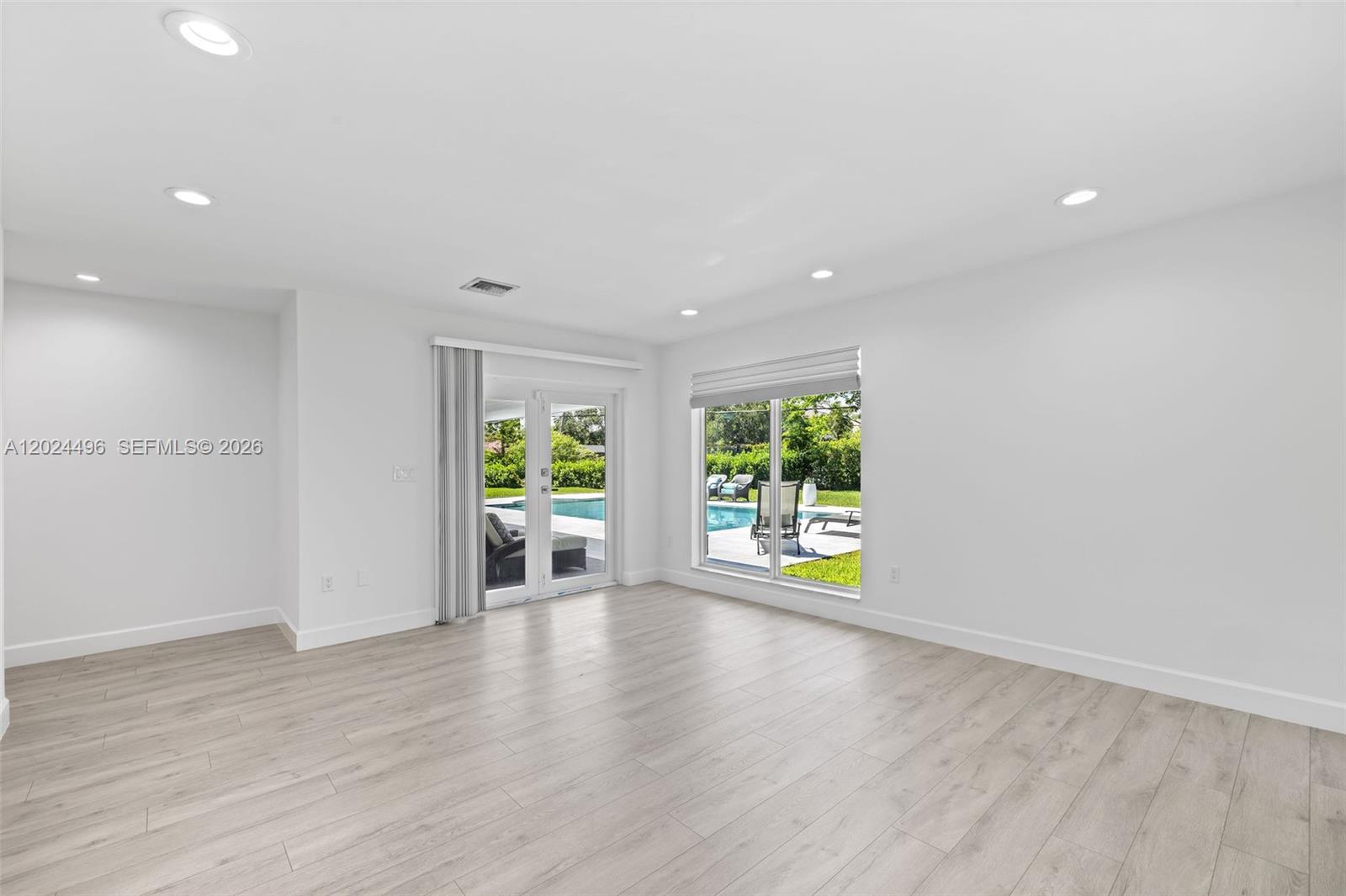6875 North Cartee Road Palmetto Bay, FL 33158 - Photo 24 of 42 an empty room with wooden floor and windows