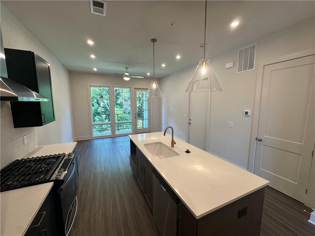 962 Bibb Street Northwest, Unit 6 Atlanta, GA 30318 - Photo 3 of 14 a kitchen with a sink window and wooden floor