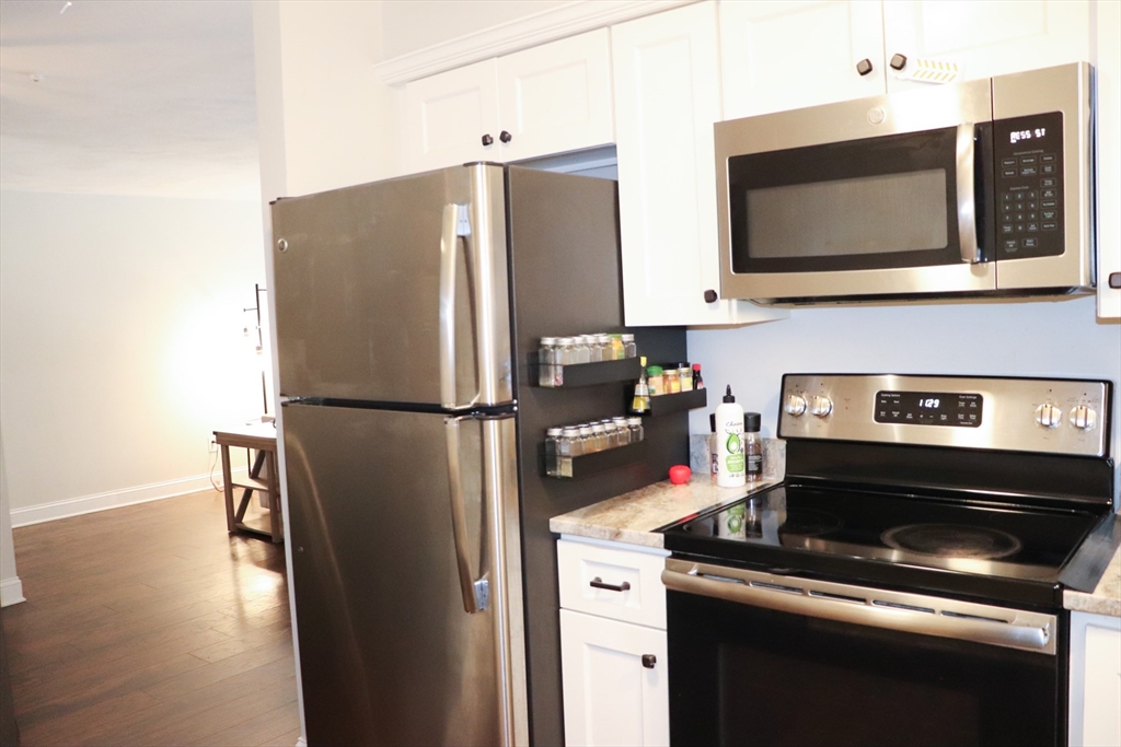 232 Canton Street, Unit 112 Randolph, MA 02368 - Photo 12 of 13 a kitchen with stainless steel appliances a refrigerator a stove and a microwave