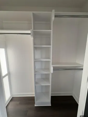 a view of walk in closet with empty racks