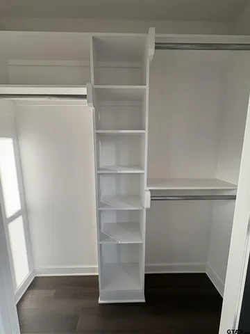 a view of walk in closet with empty racks