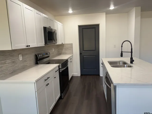 a kitchen with a sink stove and microwave