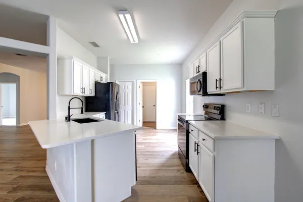 a kitchen with stainless steel appliances granite countertop a sink stove and refrigerator