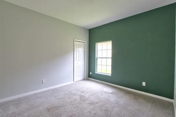 an empty room with a ceiling fan and window