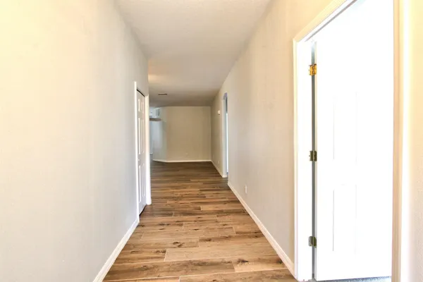 a view of a hallway with wooden floor
