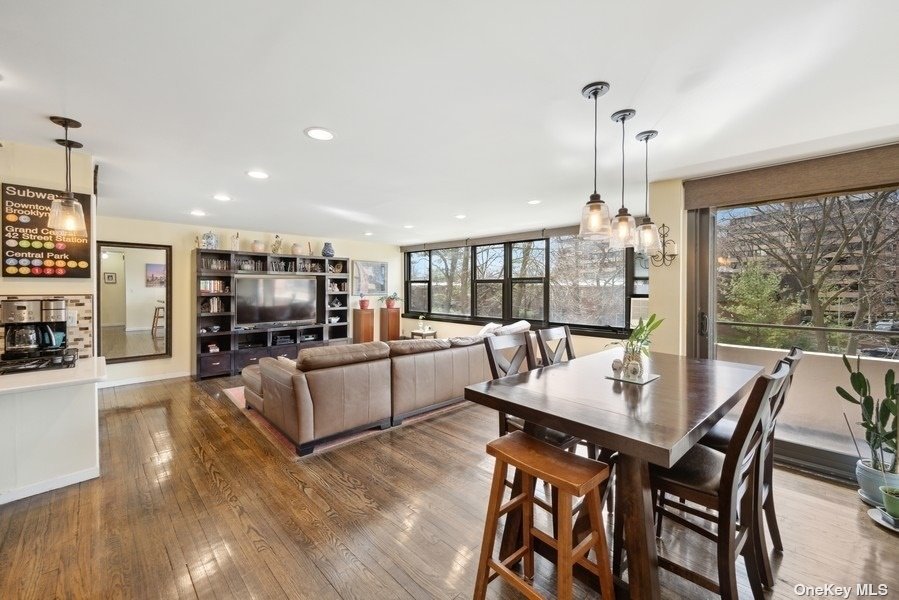 a view of a dining room and livingroom with furniture wooden floor a chandelier