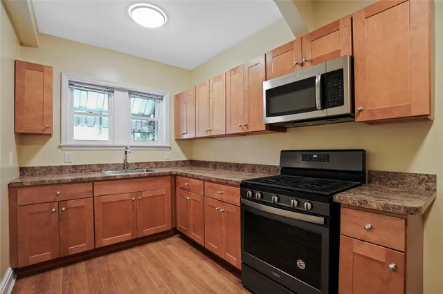 a kitchen with stainless steel appliances granite countertop a stove a microwave and cabinets