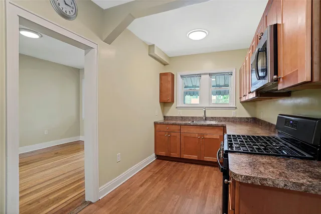 a kitchen with granite countertop wooden cabinets and a stove top oven