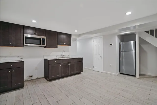 a large kitchen with a sink and stainless steel appliances