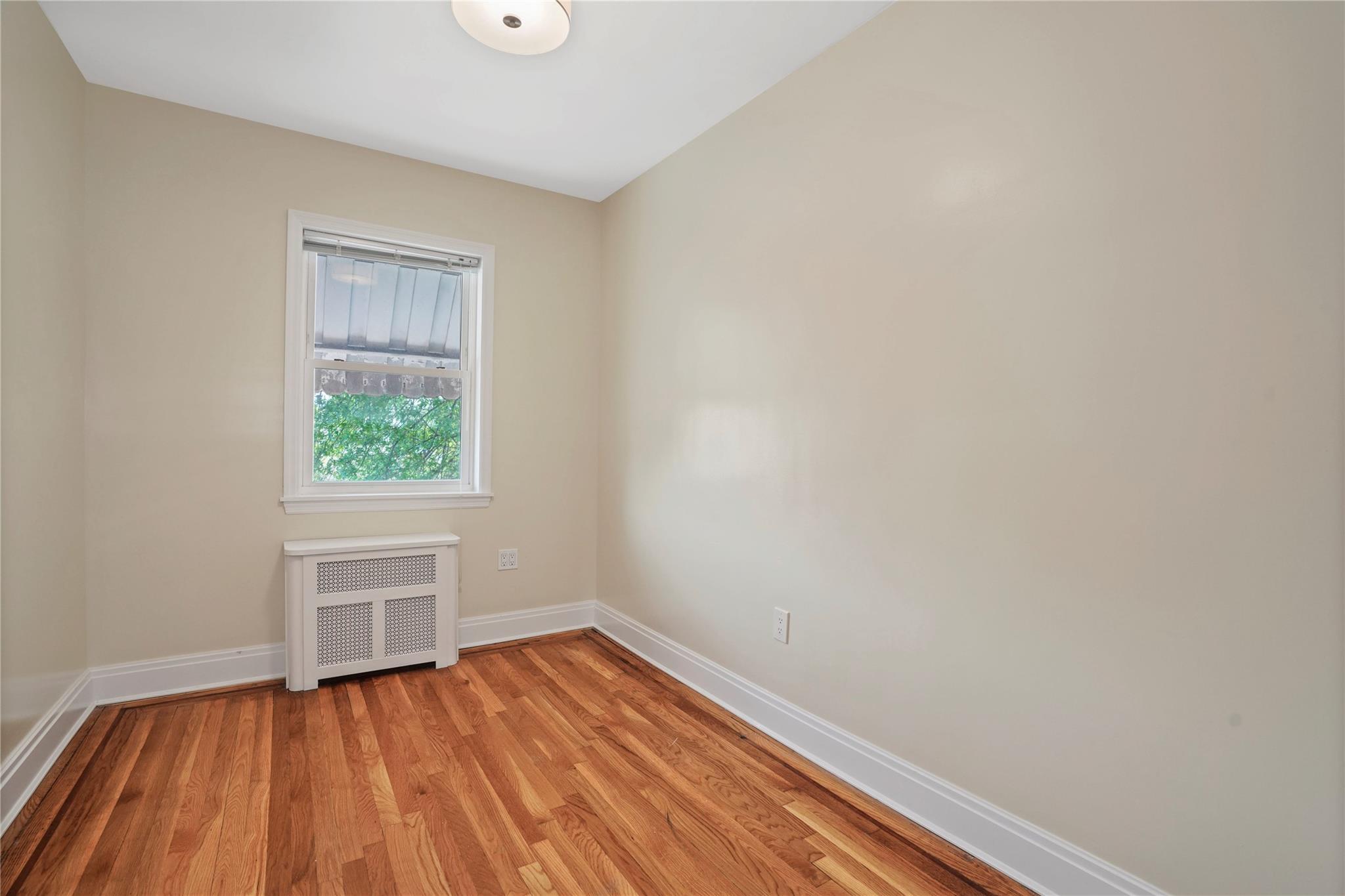 64-18 84th Place Queens, NY 11379 - Photo 32 of 35 a view of a room with wooden floor and window