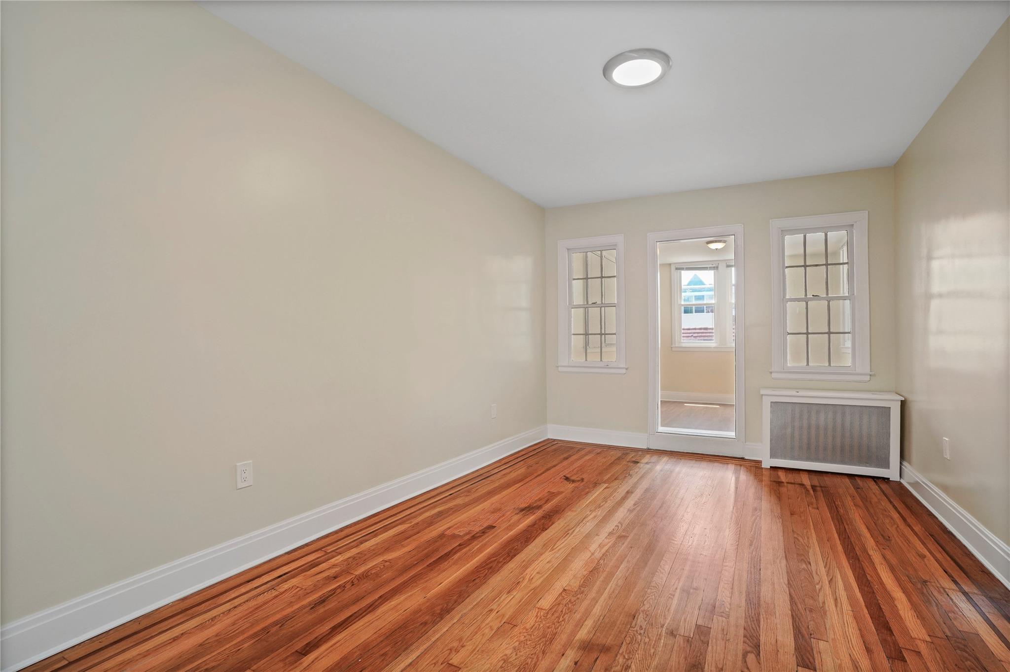 64-18 84th Place Queens, NY 11379 - Photo 6 of 35 wooden floor in an empty room with a window