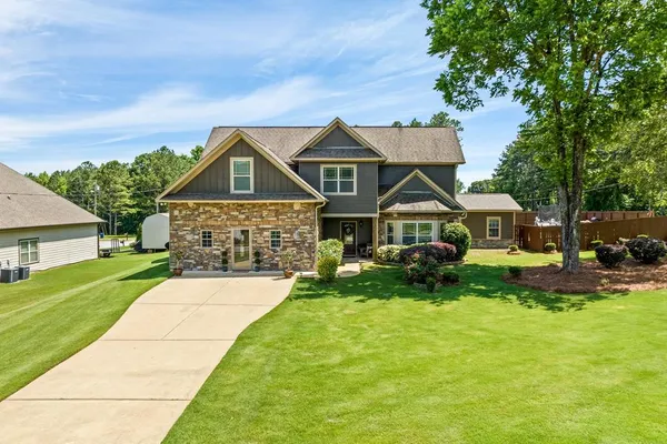a front view of a house with yard and green space