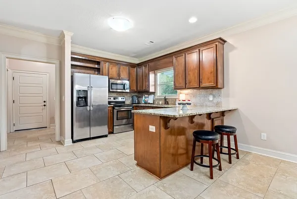 a kitchen with granite countertop a refrigerator cabinets and a stove top oven