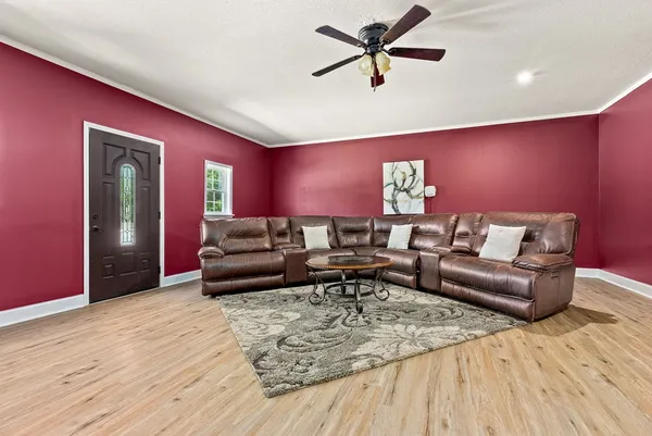 a living room with furniture and a wooden floor