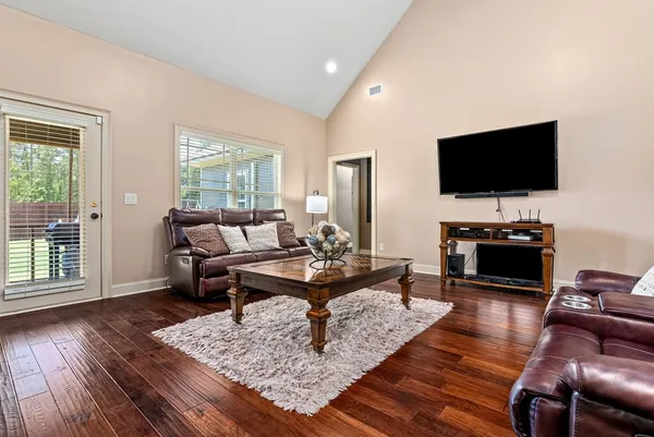 a living room with furniture a flat screen tv and a large window
