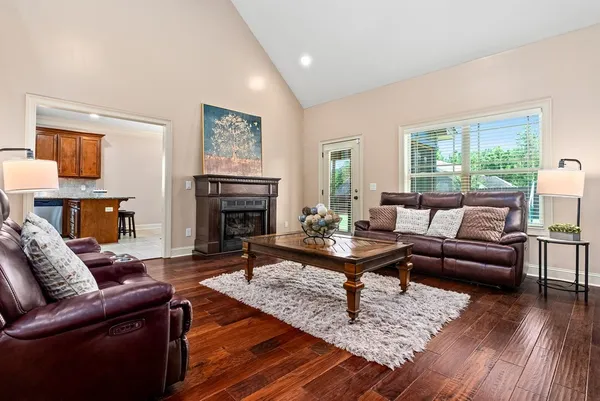 a living room with furniture a fireplace and wooden floor