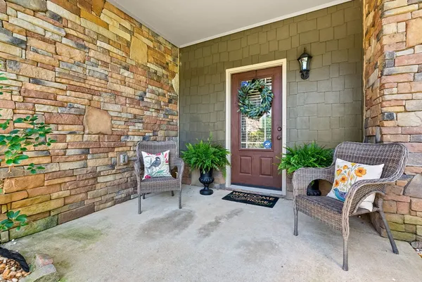 a view of a patio with couches and a potted plant on the wall