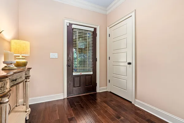 an empty room with wooden floor cabinet and windows