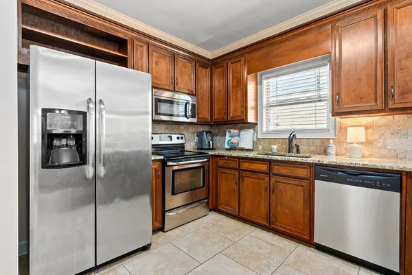 a kitchen with stainless steel appliances granite countertop a refrigerator and a sink