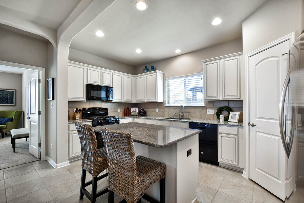 3451 Mayfield Ranch Boulevard, Unit 216 Round Rock, TX 78681 - Photo 11 of 33 a kitchen with stainless steel appliances granite countertop a refrigerator a stove a sink a dining table and chairs