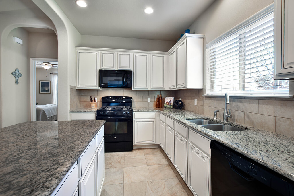 3451 Mayfield Ranch Boulevard, Unit 216 Round Rock, TX 78681 - Photo 13 of 33 a kitchen with stainless steel appliances granite countertop a sink stove and refrigerator