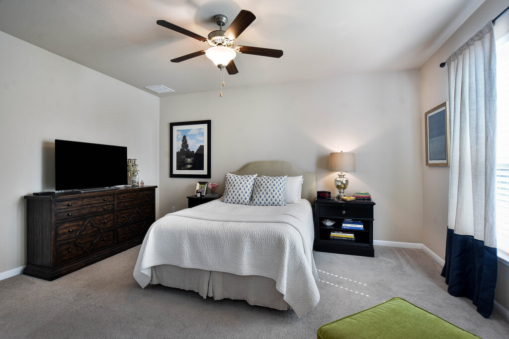 3451 Mayfield Ranch Boulevard, Unit 216 Round Rock, TX 78681 - Photo 16 of 33 a spacious bedroom with a bed and a flat screen tv