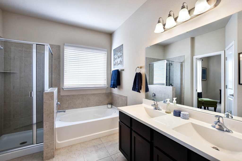 3451 Mayfield Ranch Boulevard, Unit 216 Round Rock, TX 78681 - Photo 19 of 33 a bathroom with a tub double sink window and a mirror