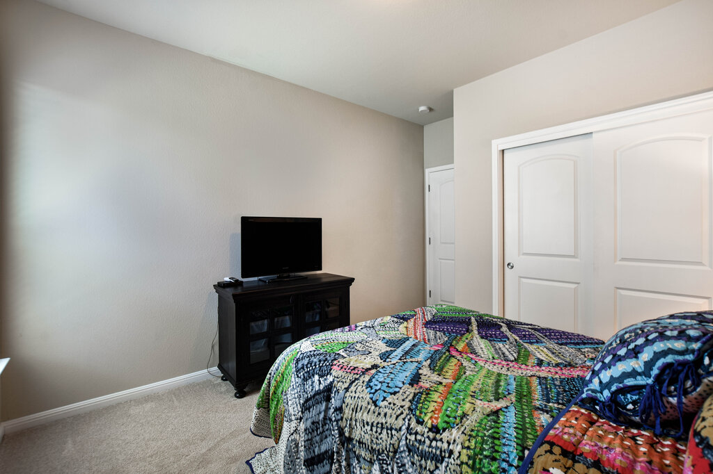 3451 Mayfield Ranch Boulevard, Unit 216 Round Rock, TX 78681 - Photo 23 of 33 a bedroom with a bed and flat screen tv