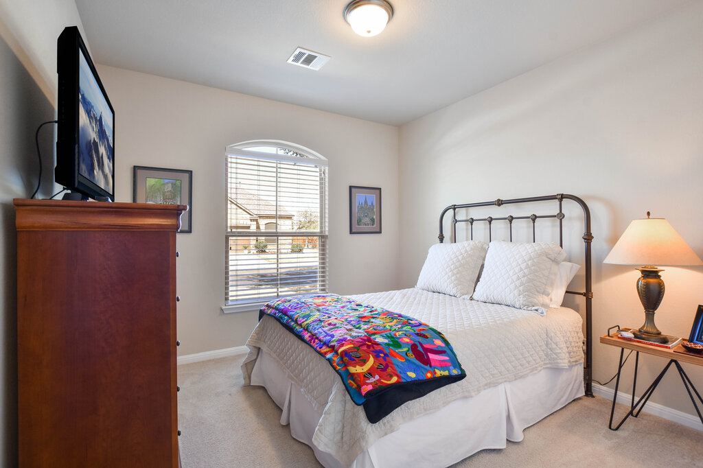3451 Mayfield Ranch Boulevard, Unit 216 Round Rock, TX 78681 - Photo 25 of 33 a bedroom with a bed lamp and a window